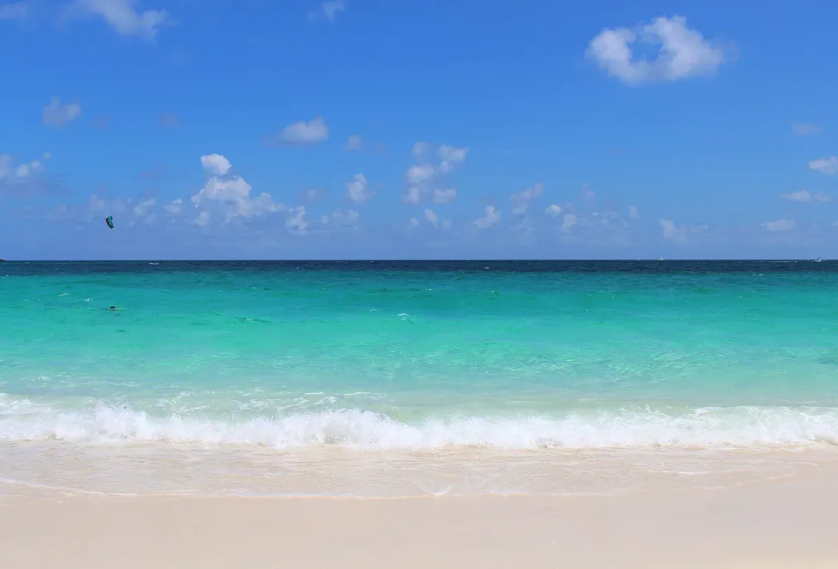 Turquoise water and white sand on a Bahamas beach, the day to pack for on a Bahamas cruise